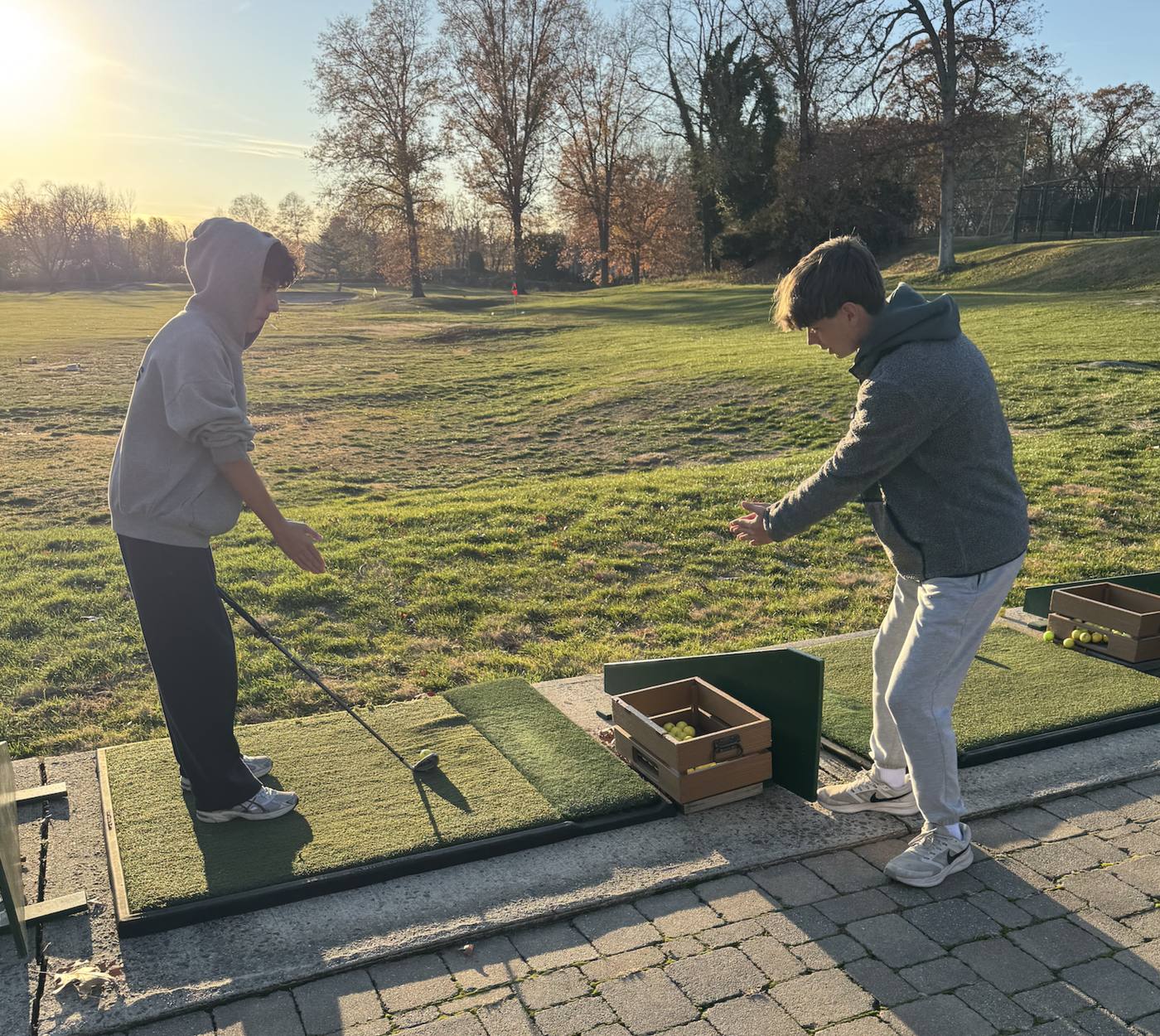 Mentor and student running a drill at the driving range