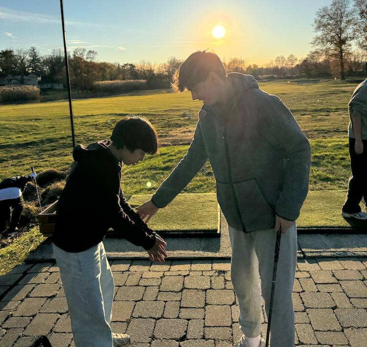 Mentor and student at the driving range at sunset